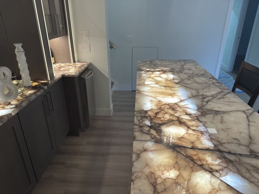 Close view of the backlit stone countertop with light showing through the veins