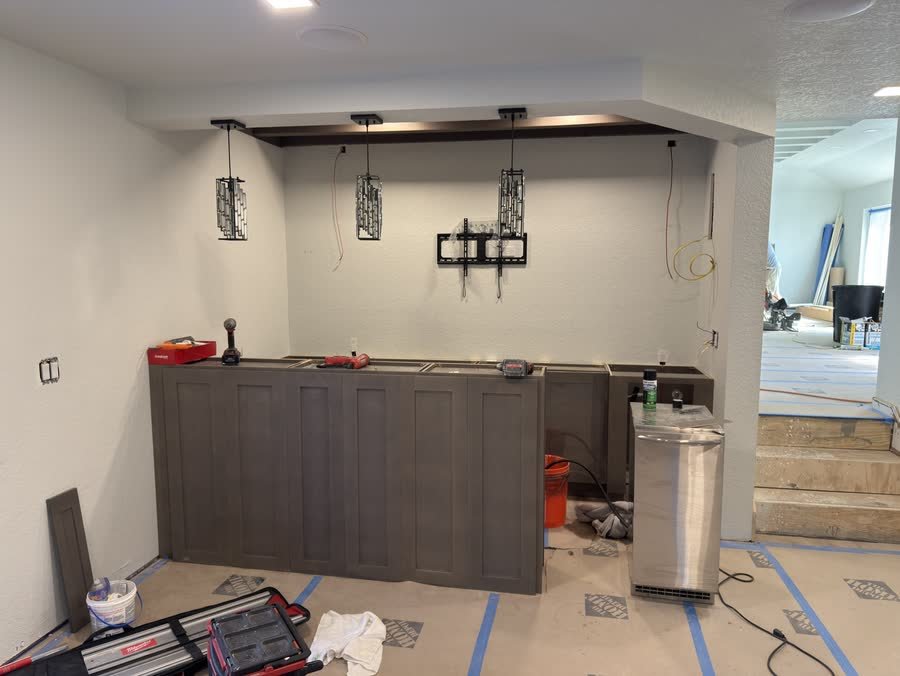 Bar cabinets set and leveled with pendant lights hung, before the countertop