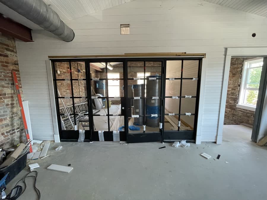 Steel and glass doors installed in a room with bare concrete floors