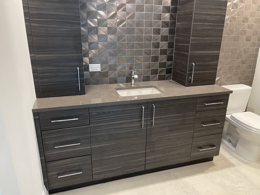 Bathroom with large format floor tile and a dark wood grain vanity