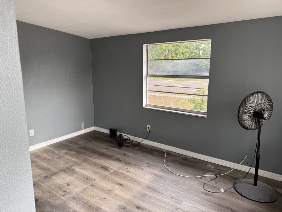 Finished room with grey walls, white baseboards and new vinyl plank floors