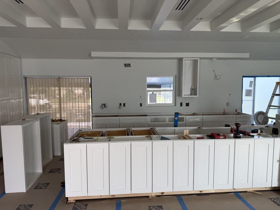 White island and perimeter cabinets set and leveled on a protected floor