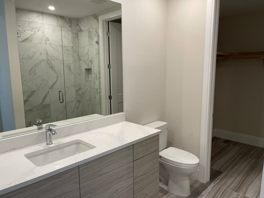 Bathroom with a marble look shower and modern vanity