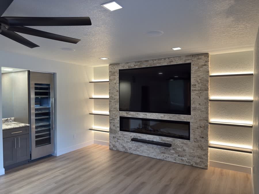 Living room with the stone media wall and a built-in wine fridge beside it
