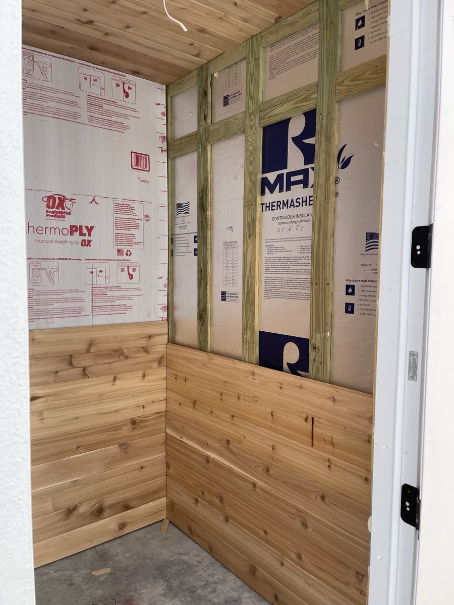 Sauna walls insulated and sealed with the first rows of cedar going on