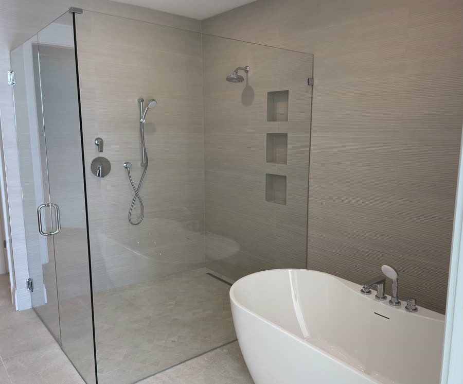 Curbless walk-in shower next to a freestanding tub