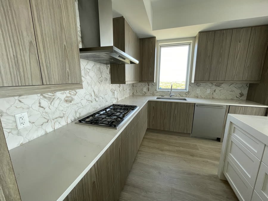 Kitchen with wood grain cabinets and a stone backsplash